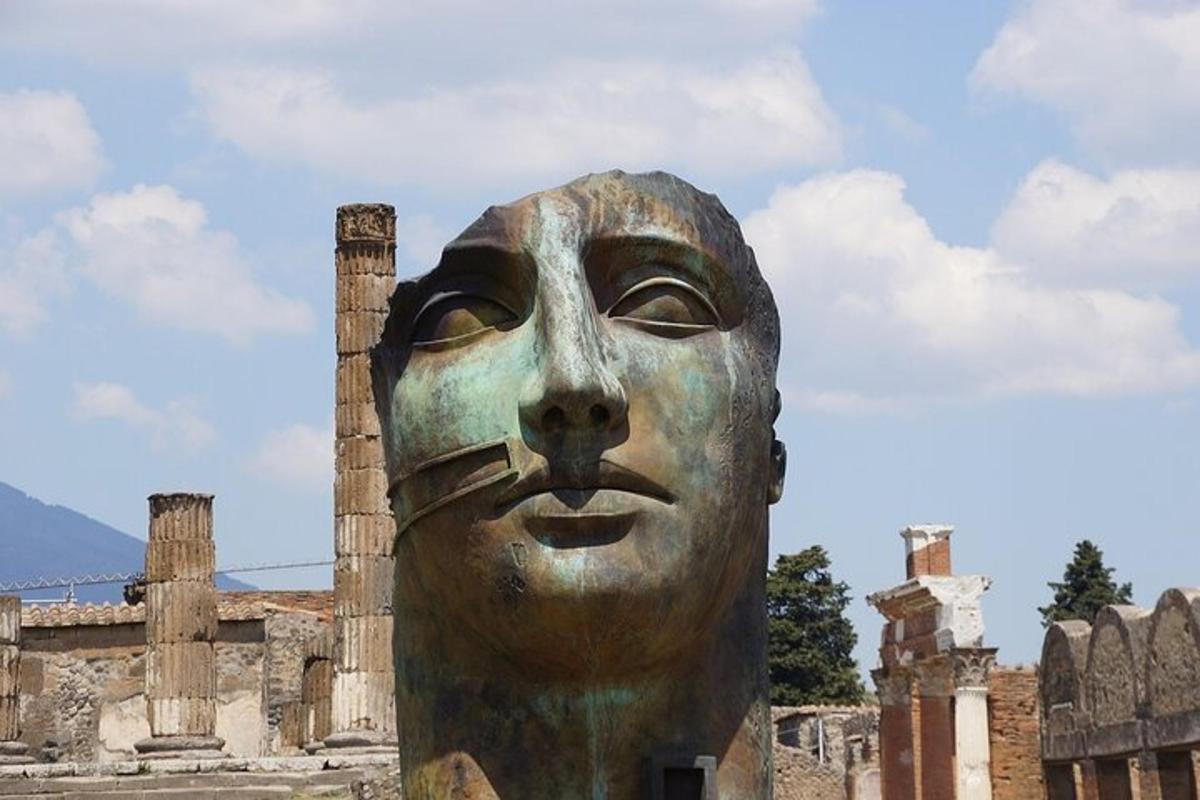 una statua di un volto di fronte a un edificio
