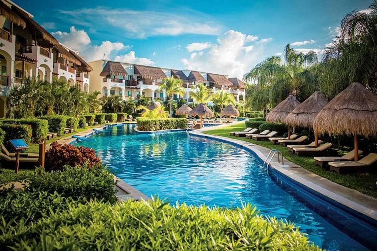 una piscina en un resort con sombrillas