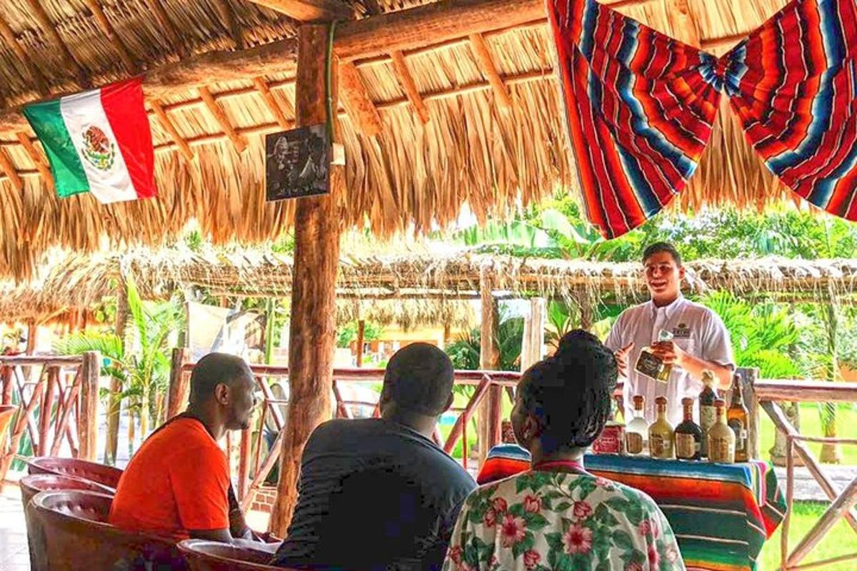 un groupe de personnes assises autour d'un bar avec un barman