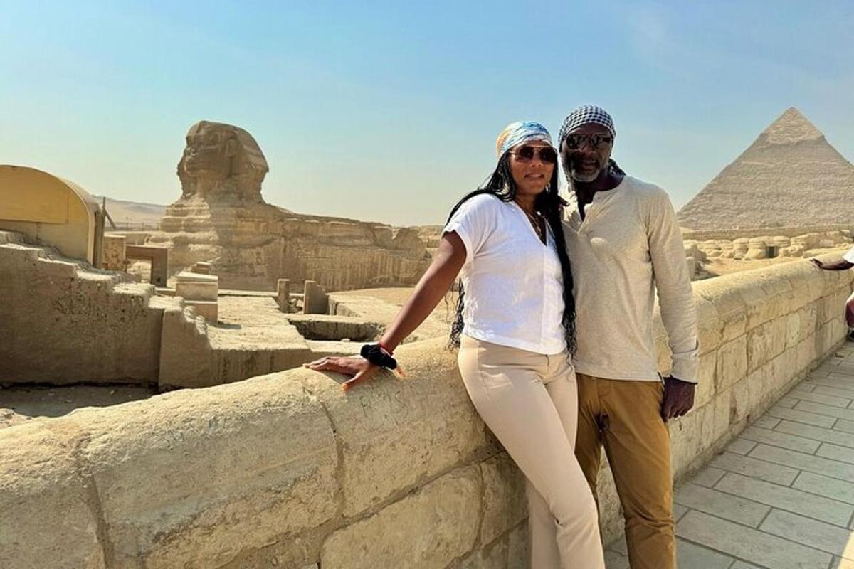 mies ja nainen seisovat muurilla lähellä pyramidia