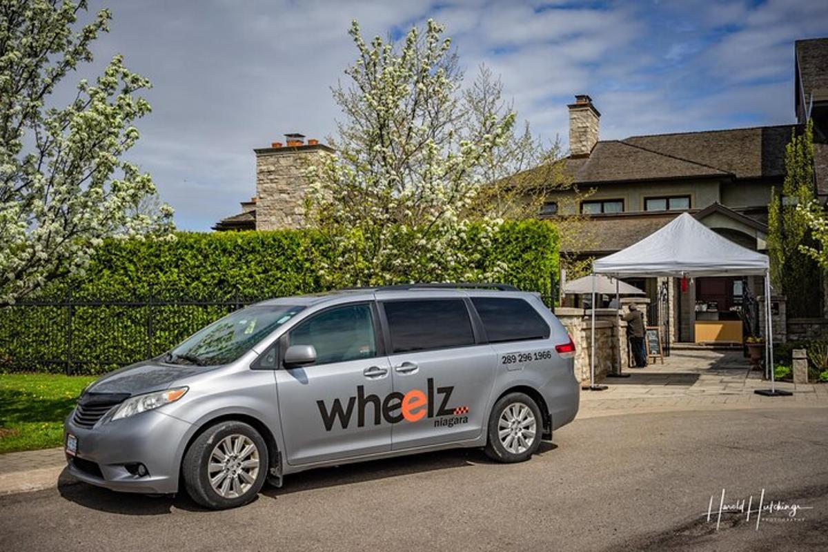 a silver minivan parked in front of a house