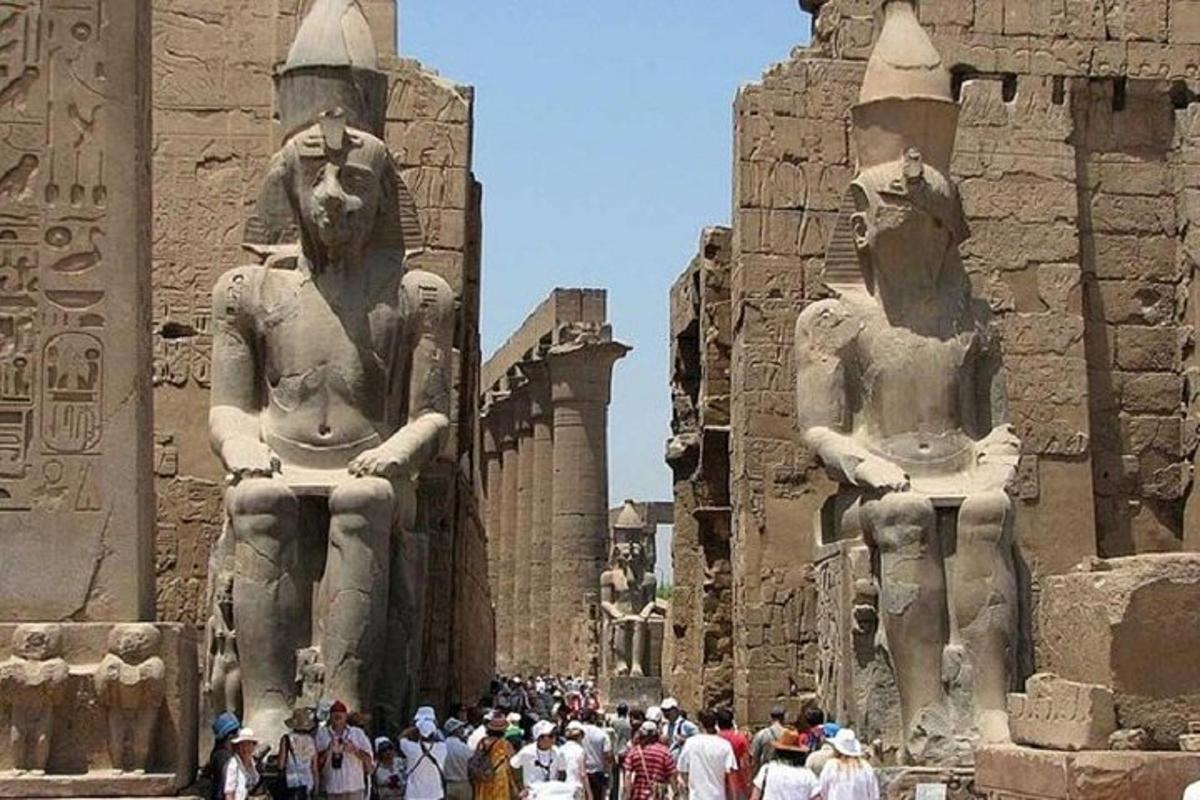 Un grupo de personas de pie frente a estatuas