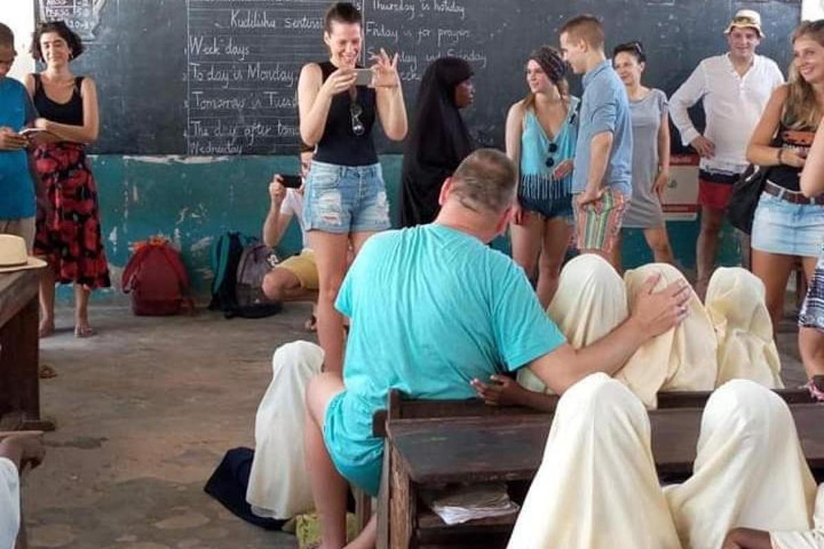 skupina ljudi, ki sedijo na klopi v učilnici