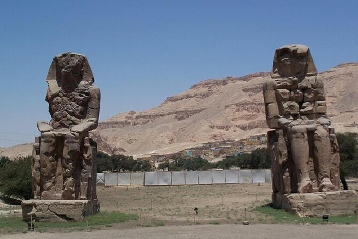 Dos grandes estatuas de piedra frente a una montaña
