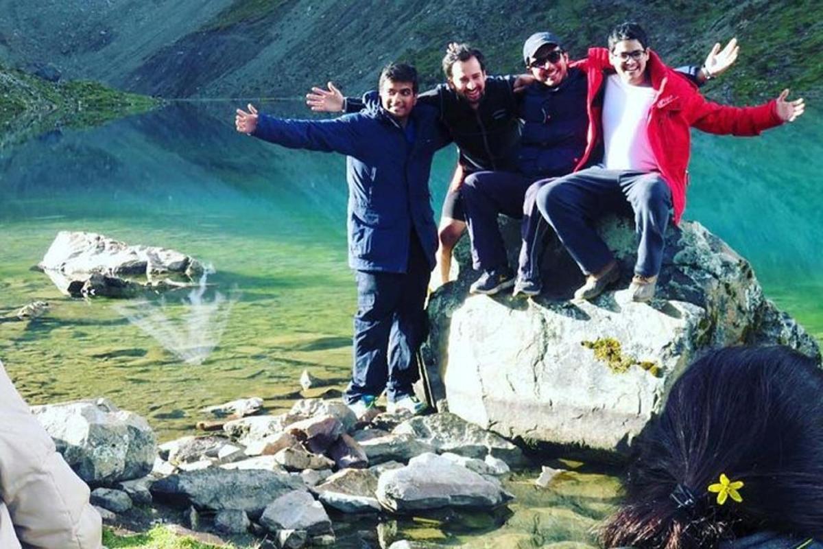 a group of people sitting on a rock near the water