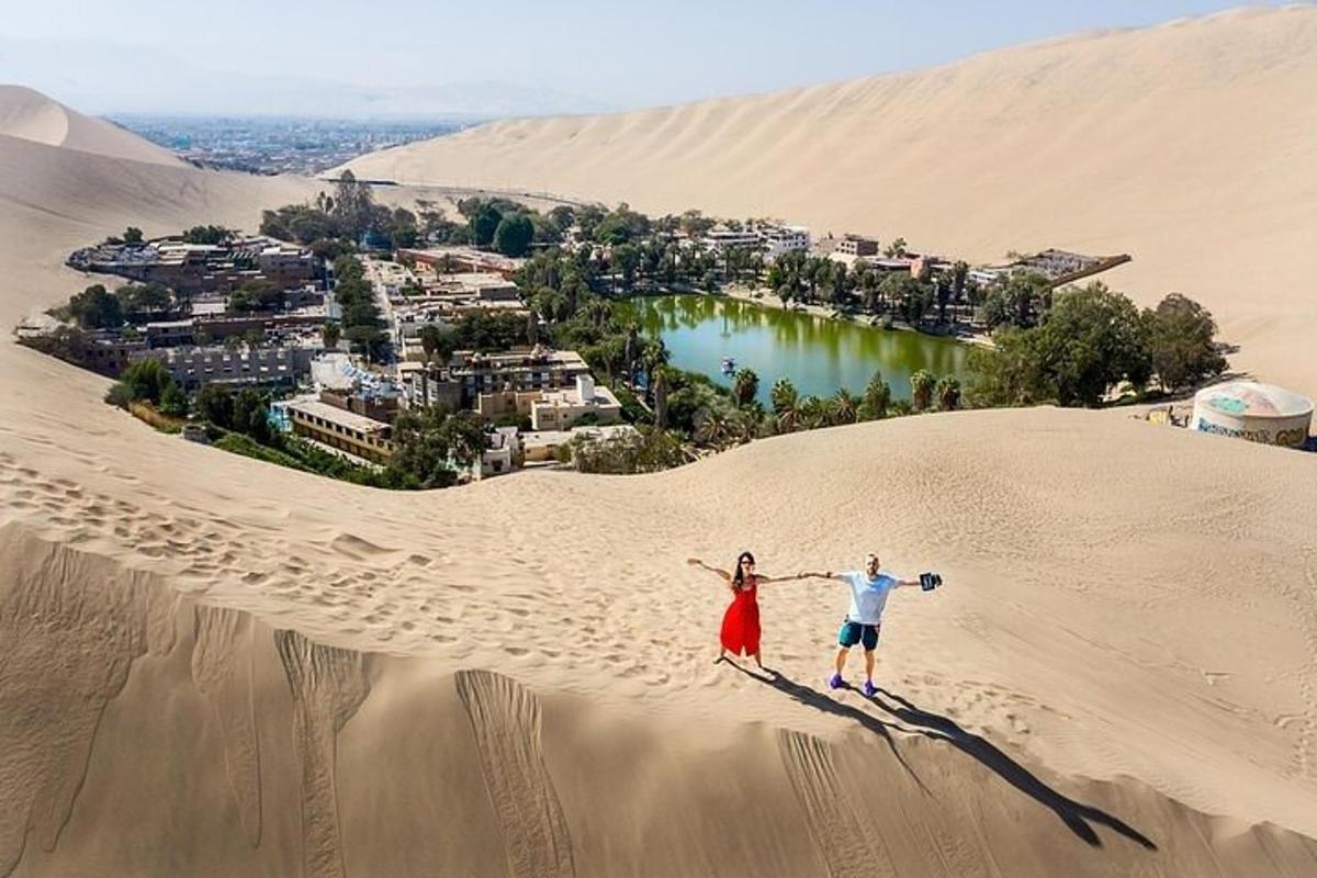 un uomo e una donna in piedi su una duna di sabbia nel deserto