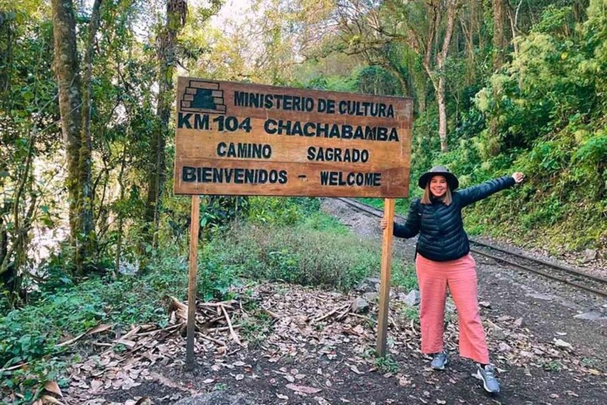una donna in piedi accanto a un cartello su un sentiero