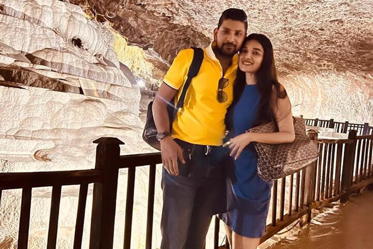 un uomo e una donna in piedi davanti a una grotta