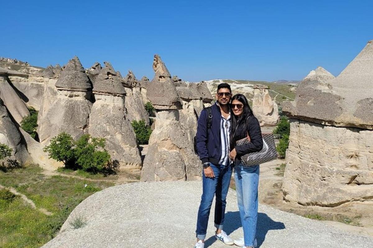 un uomo e una donna in piedi in cima a una formazione rocciosa
