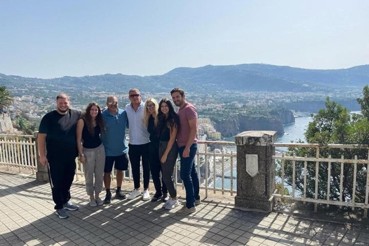 a group of people posing for a picture on a balcony