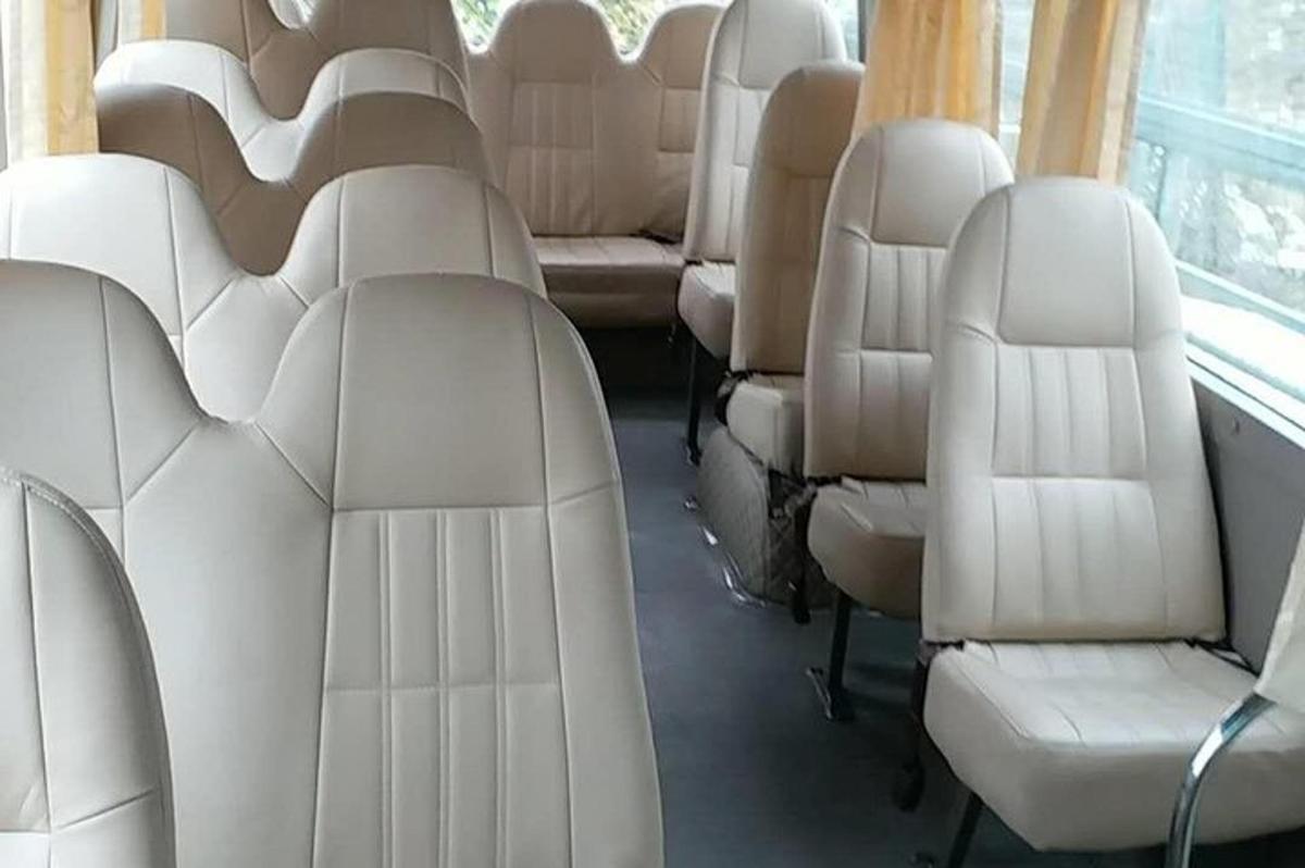 deretan tempat duduk putih di dalam bas