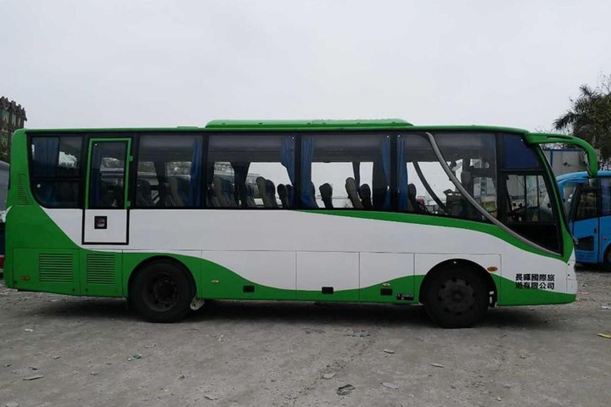 un autobus verde e bianco parcheggiato in un parcheggio