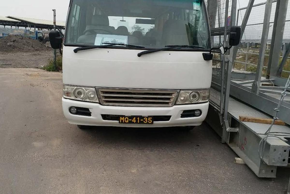 bílý autobus parkuje vedle kamionu