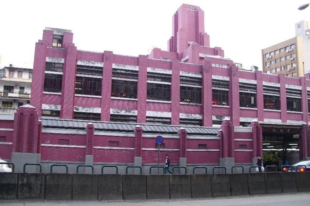 Un gran edificio rojo con una persona parada frente a él.