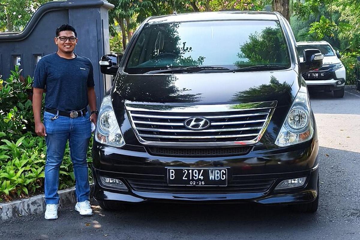 seorang lelaki sedang berdiri di hadapan sebuah kereta