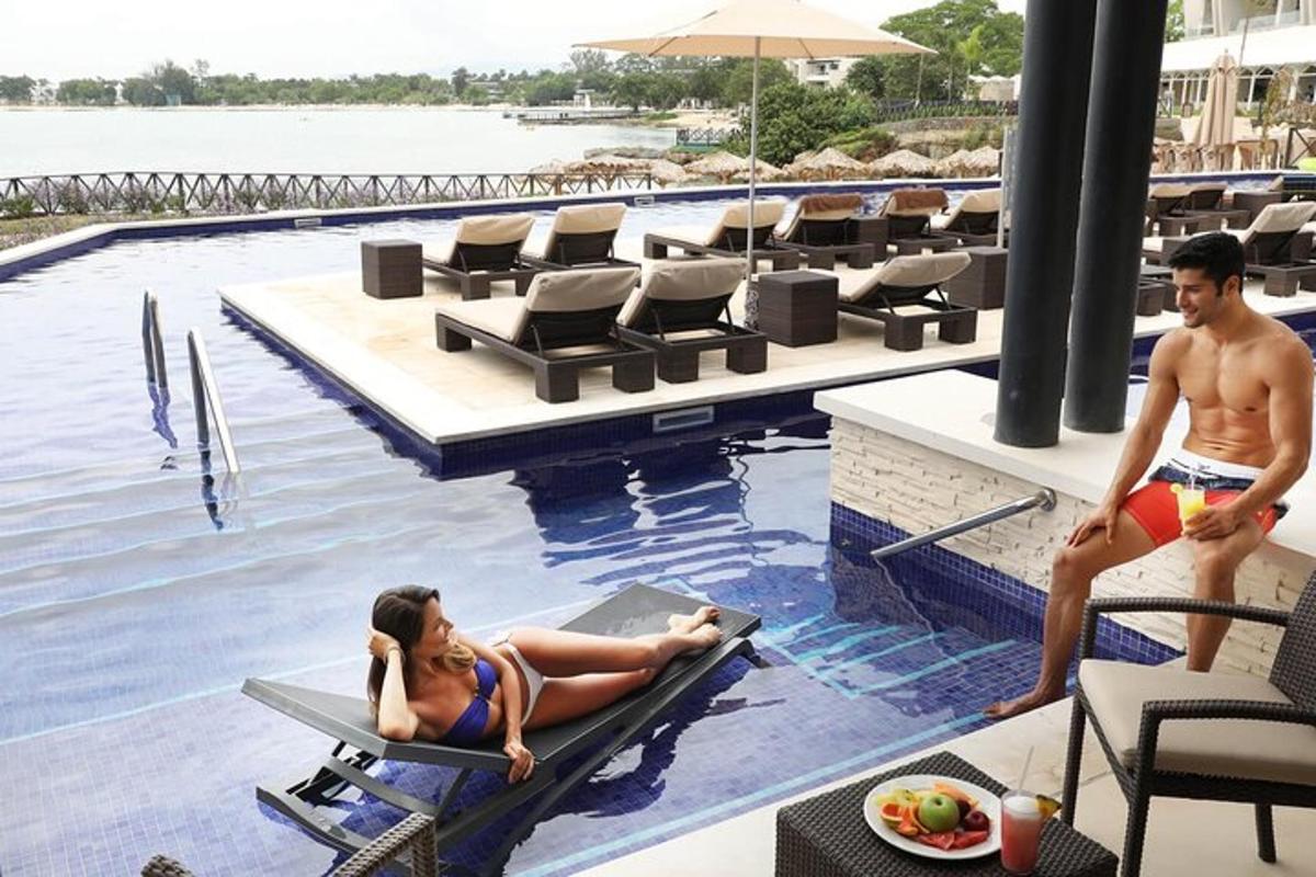 seorang lelaki dan seorang wanita duduk di kolam renang di sebuah resort