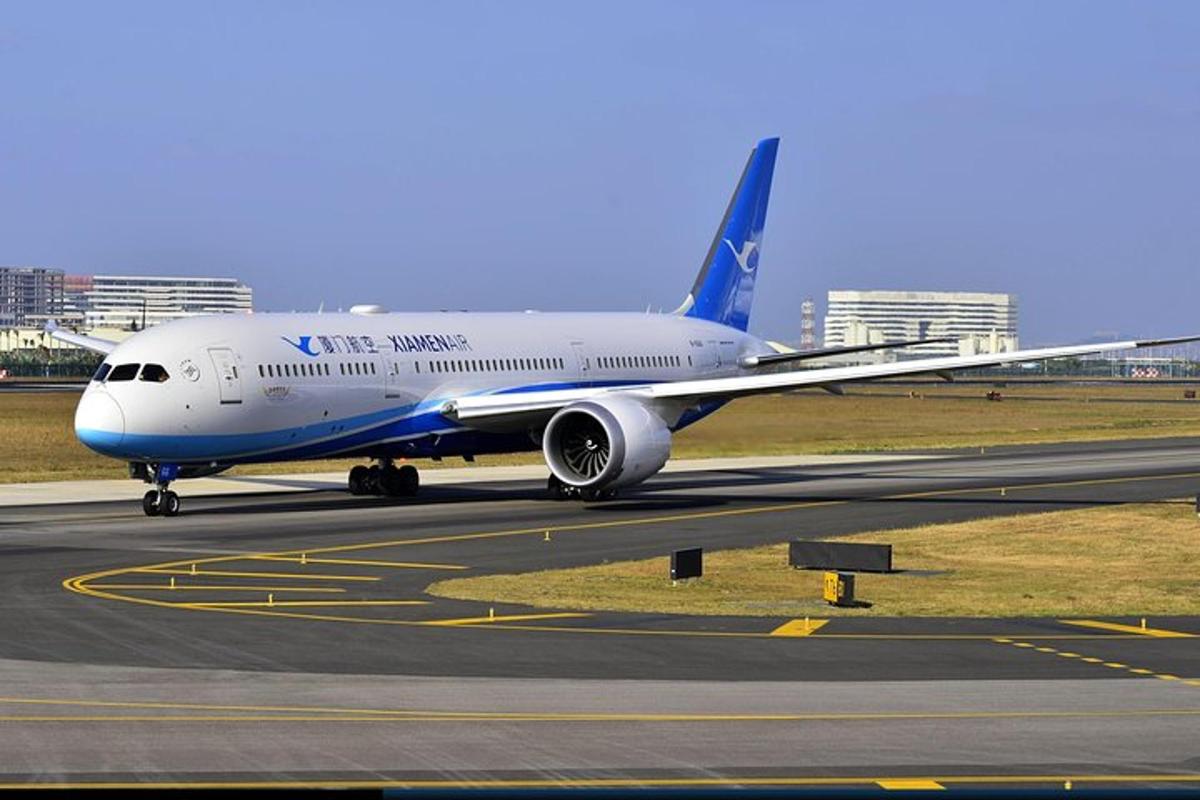 a blue and white airplane is on a runway
