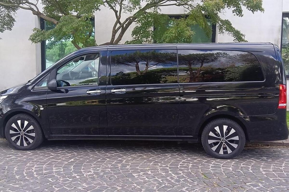 črn kombi parkiran na tlakovani ulici