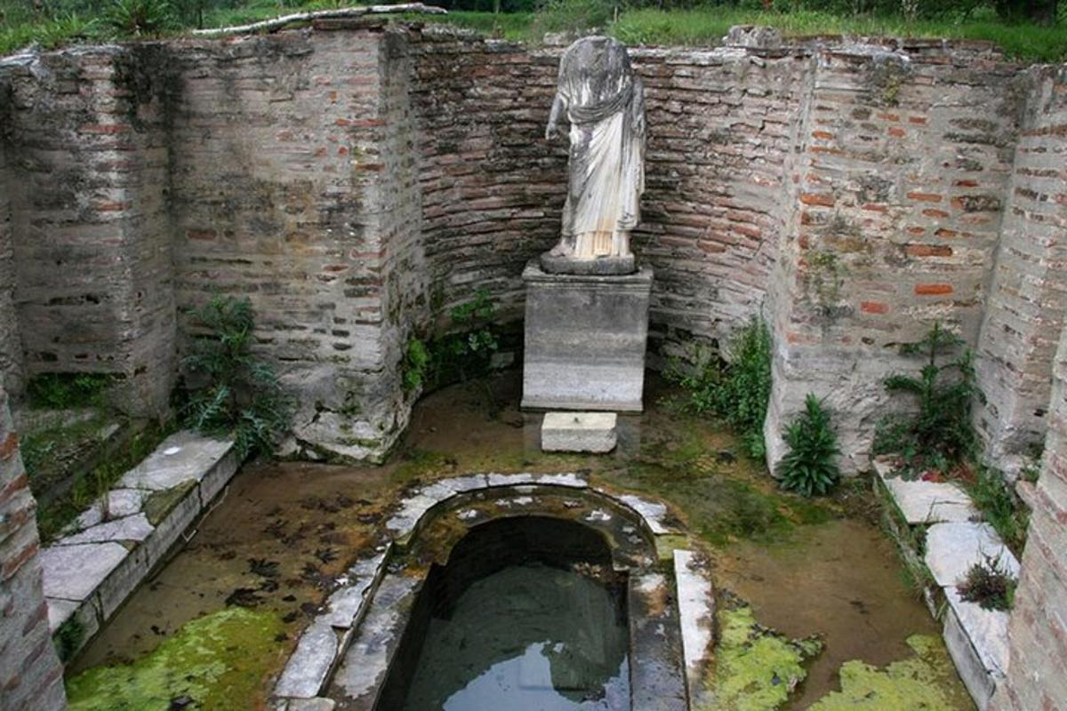 socha ženy stojící vedle cihlové zdi