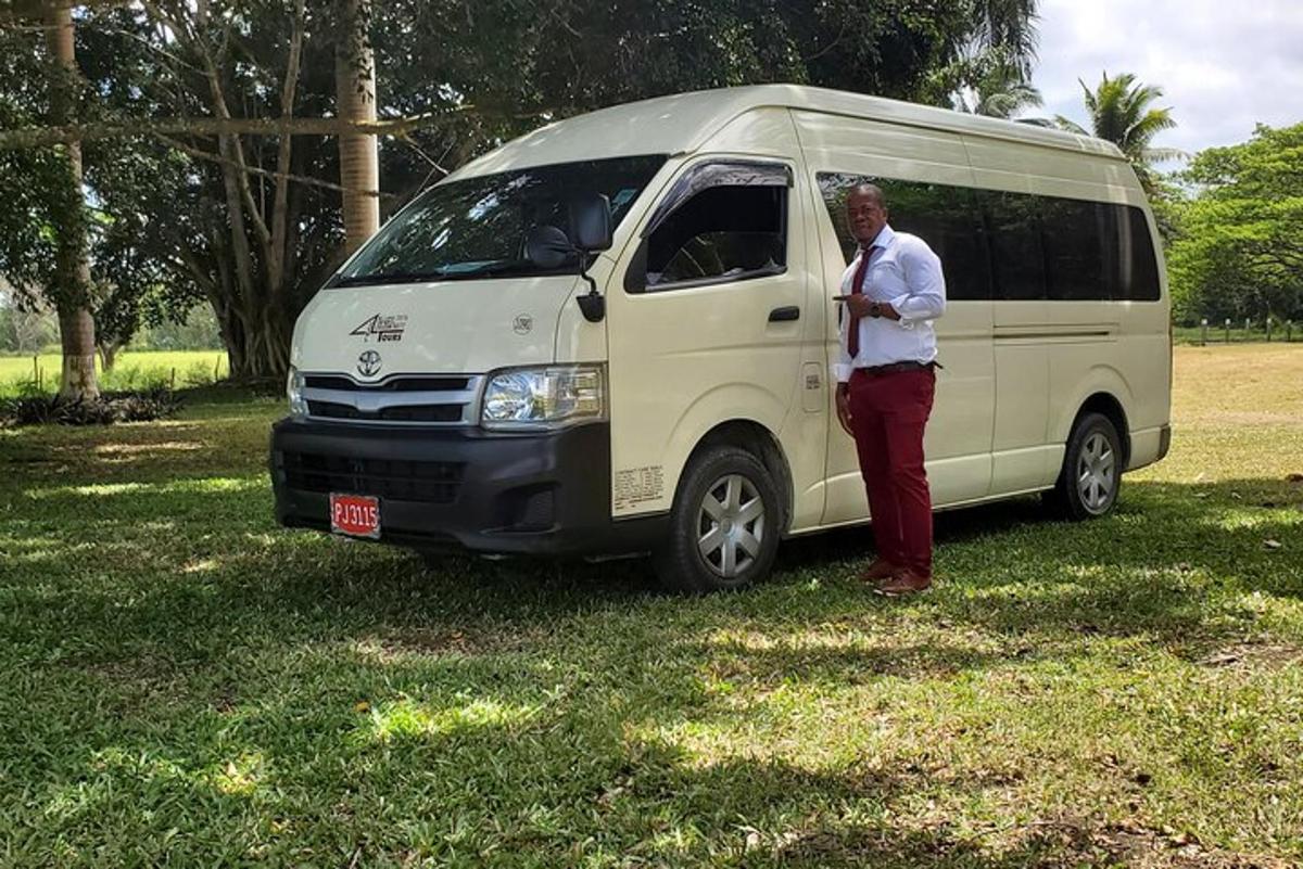 Un hombre está de pie junto a una camioneta blanca.