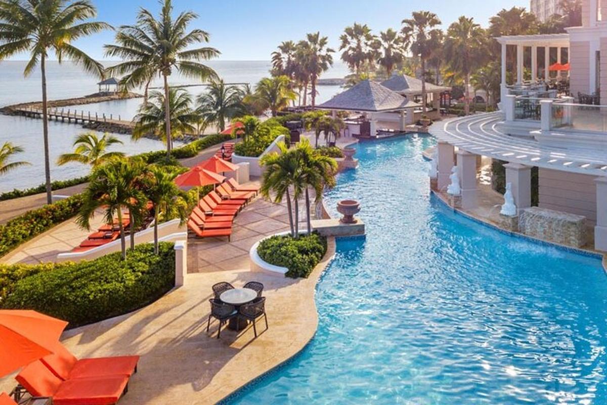 an infinity pool at a resort with palm trees and the ocean