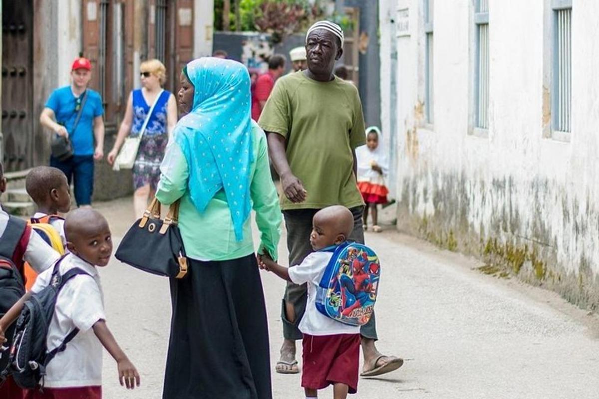 un grup de persones caminant per un carrer amb nens