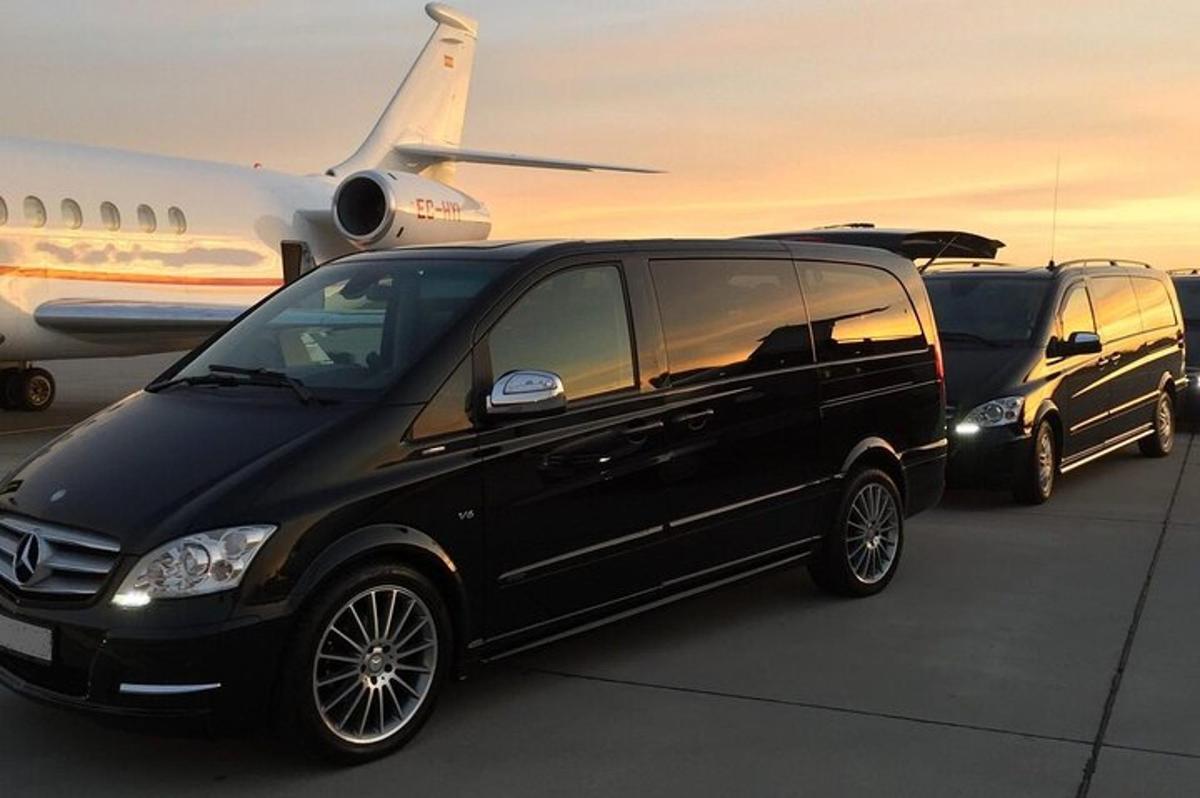 two black vans are parked next to an airplane
