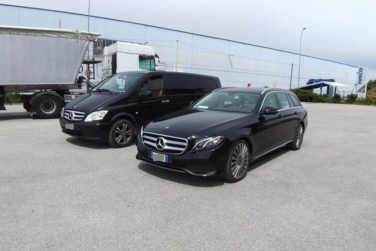 two black cars parked next to a truck