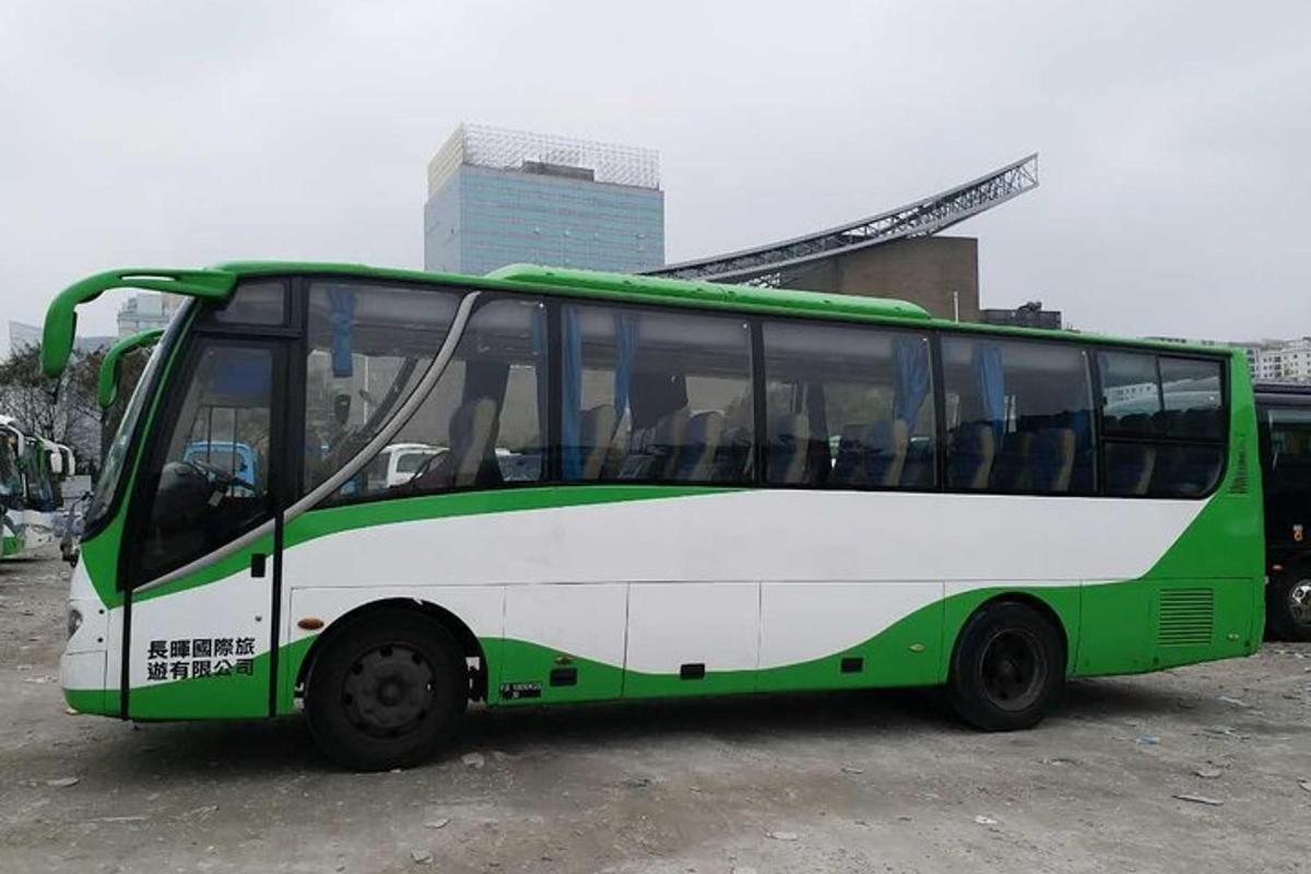 ein grün-weißer Bus auf einem Parkplatz