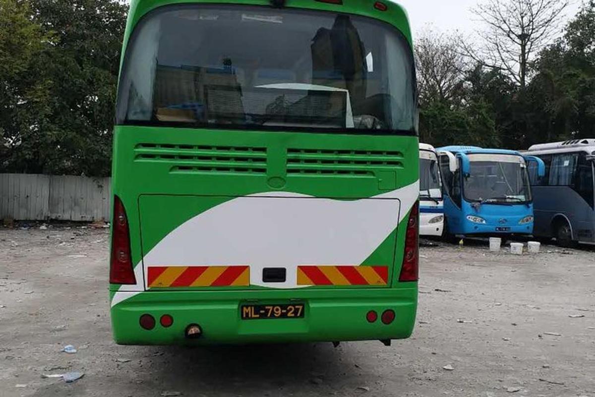 um ônibus verde e branco estacionado em um estacionamento