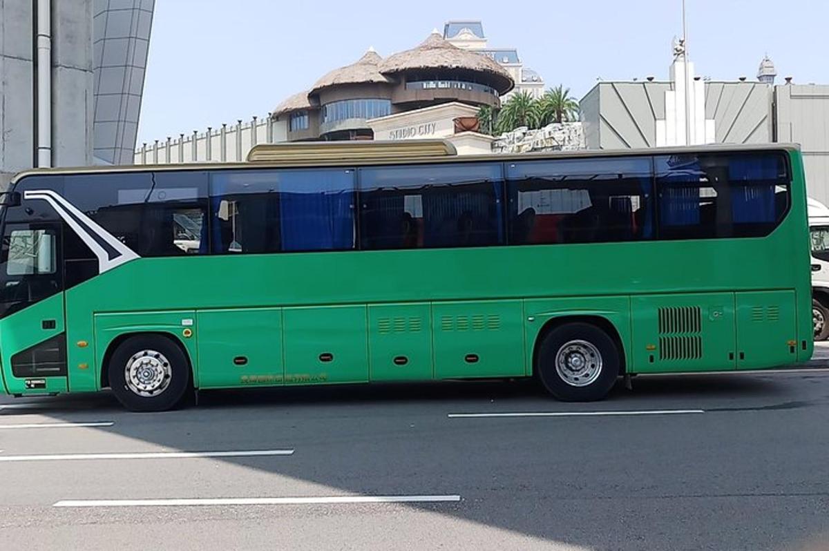 a green bus is parked in a parking lot