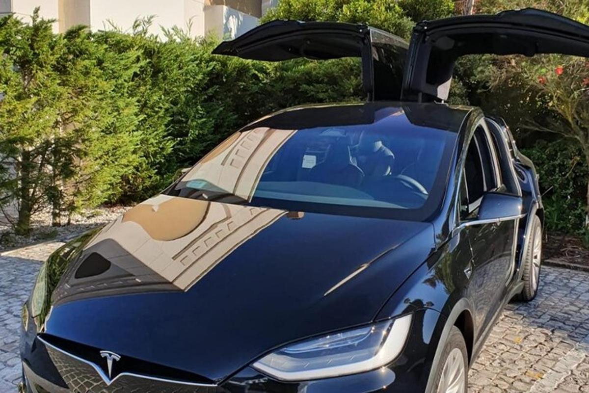a car with its doors open with a man sitting in it