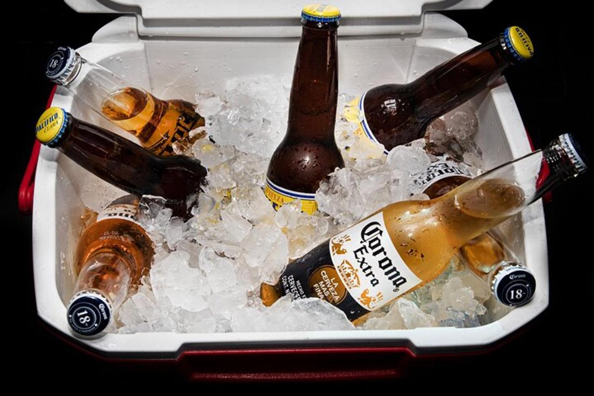 Una hielera llena de botellas de cerveza en hielo