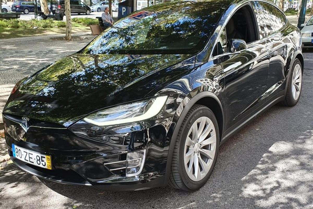 un'auto nera parcheggiata sul ciglio di una strada
