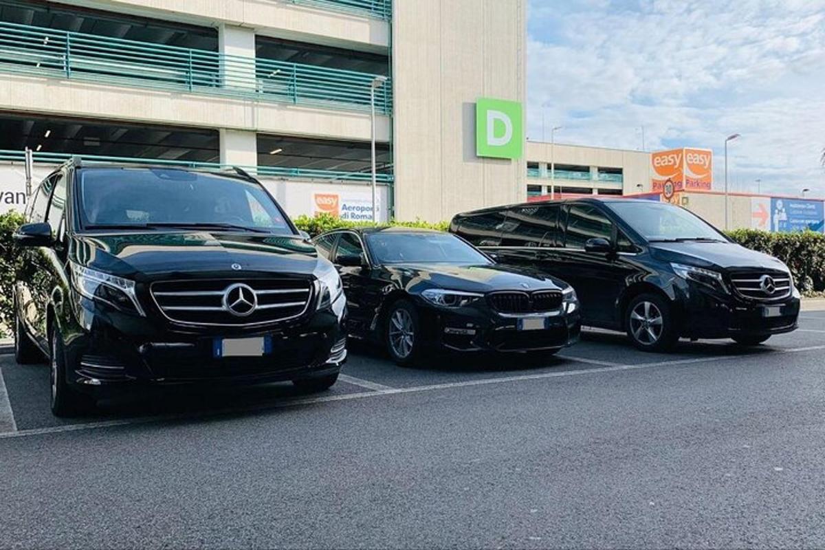 Tres coches estacionados en un estacionamiento frente a un edificio.