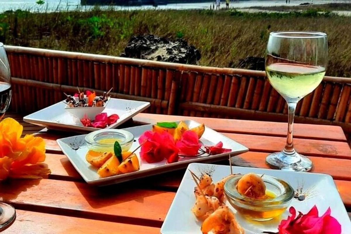 a table with three plates of food and a glass of wine