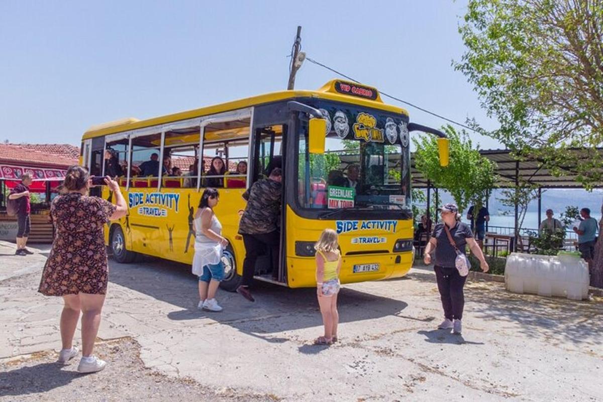 un gruppo di persone in piedi fuori da un autobus giallo