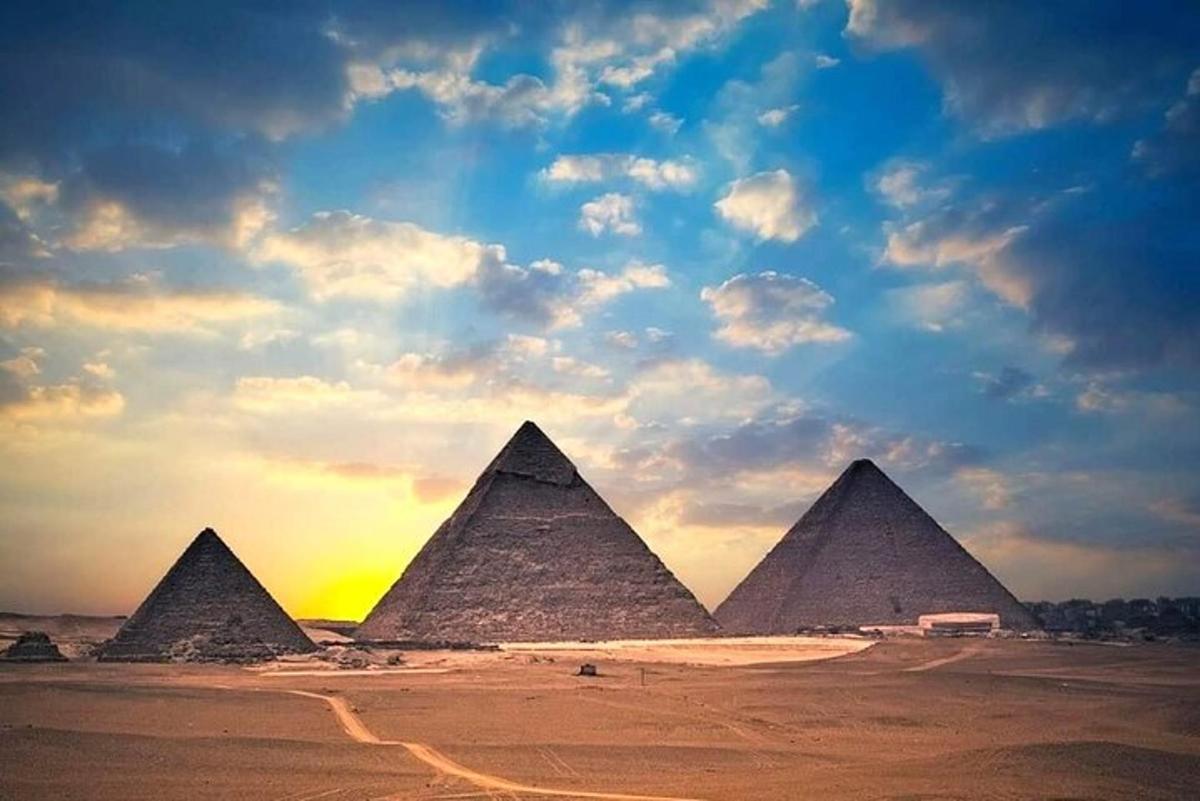 un gruppo di piramidi nel deserto sotto un cielo nuvoloso