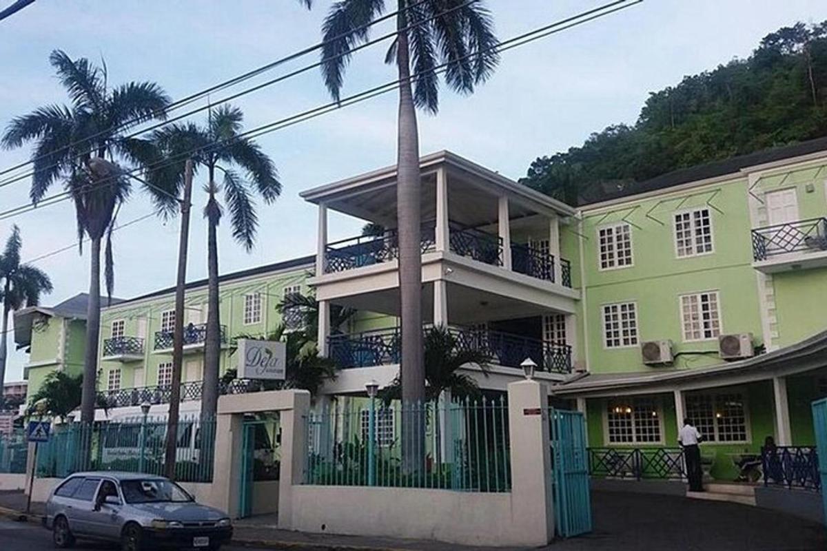 một chiếc xe đậu trước một tòa nhà có cây cọ