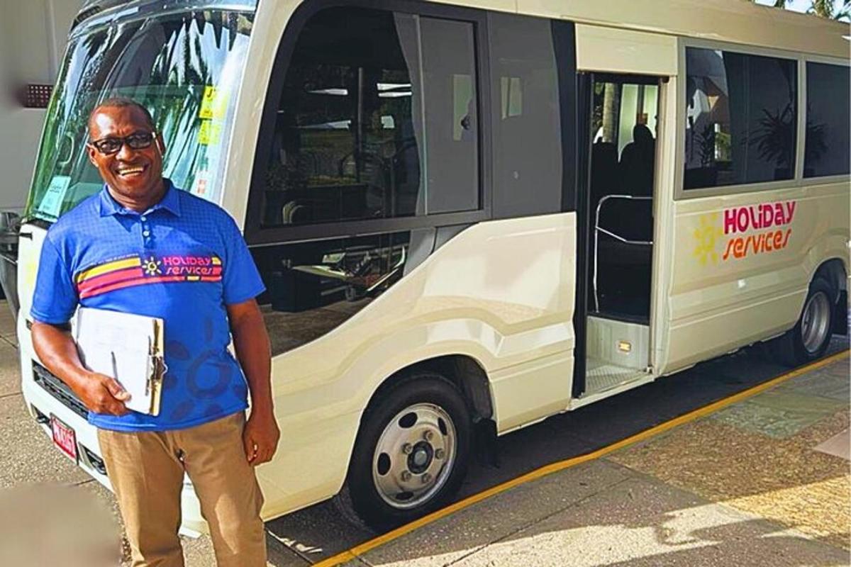 un home està dret davant d'un autobús