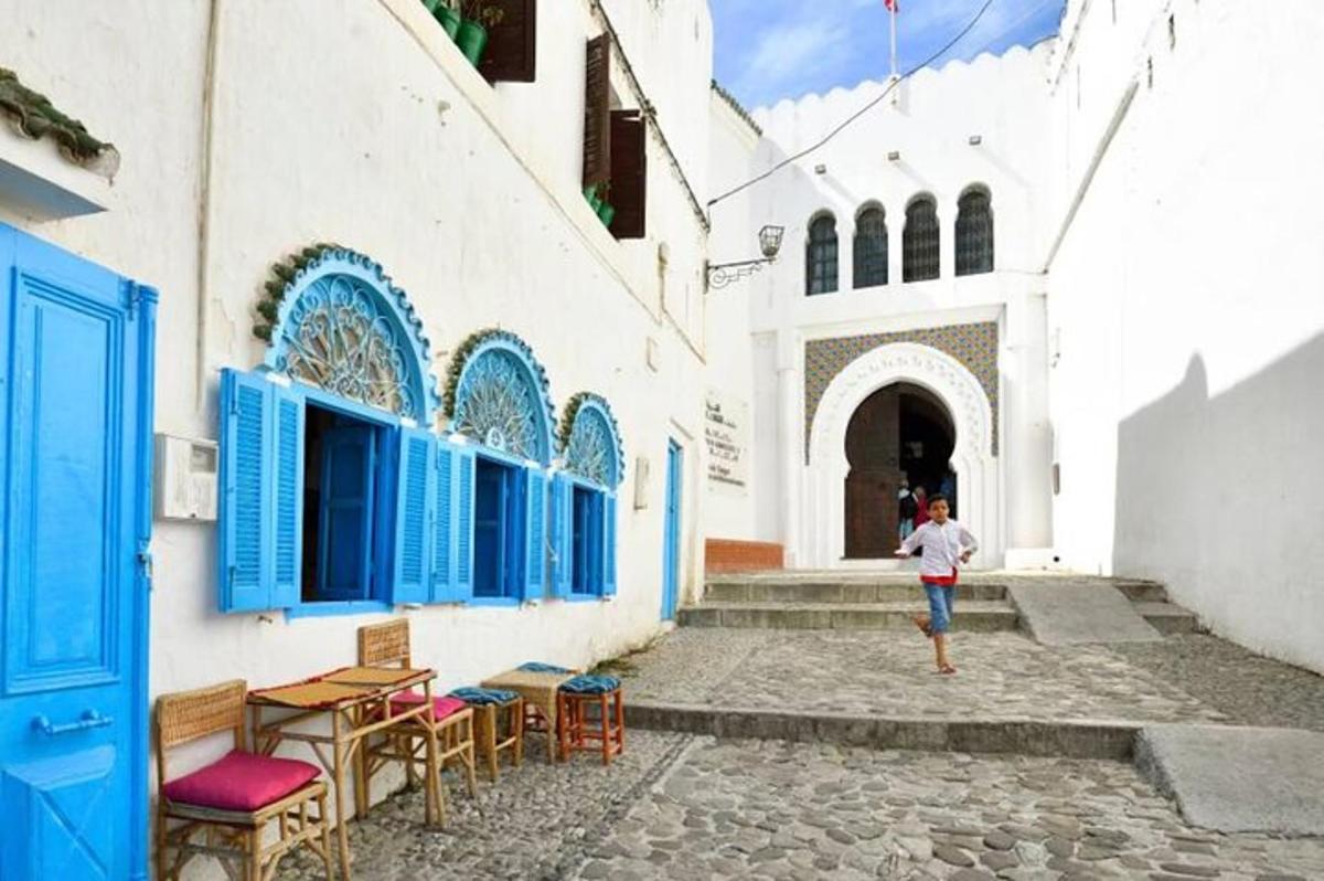 ένας άντρας περπατάει σε έναν δρόμο μπροστά από ένα κτίριο