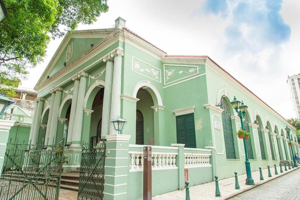 a green and white building with a fence in front of it