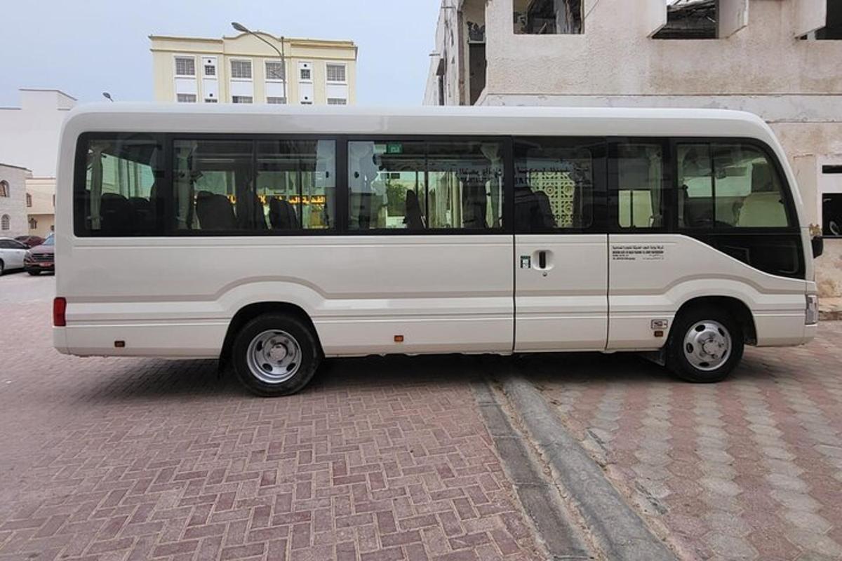 a white bus is parked on a brick street
