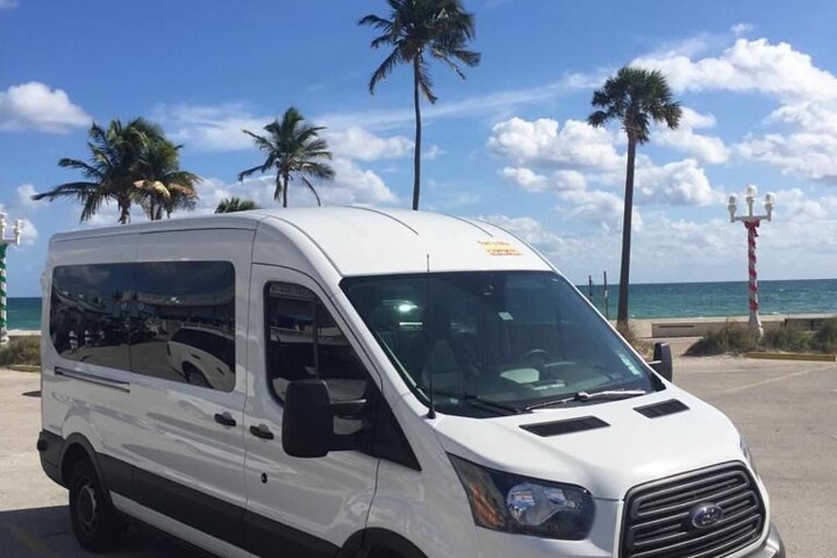 a white van parked in a parking lot next to the beach