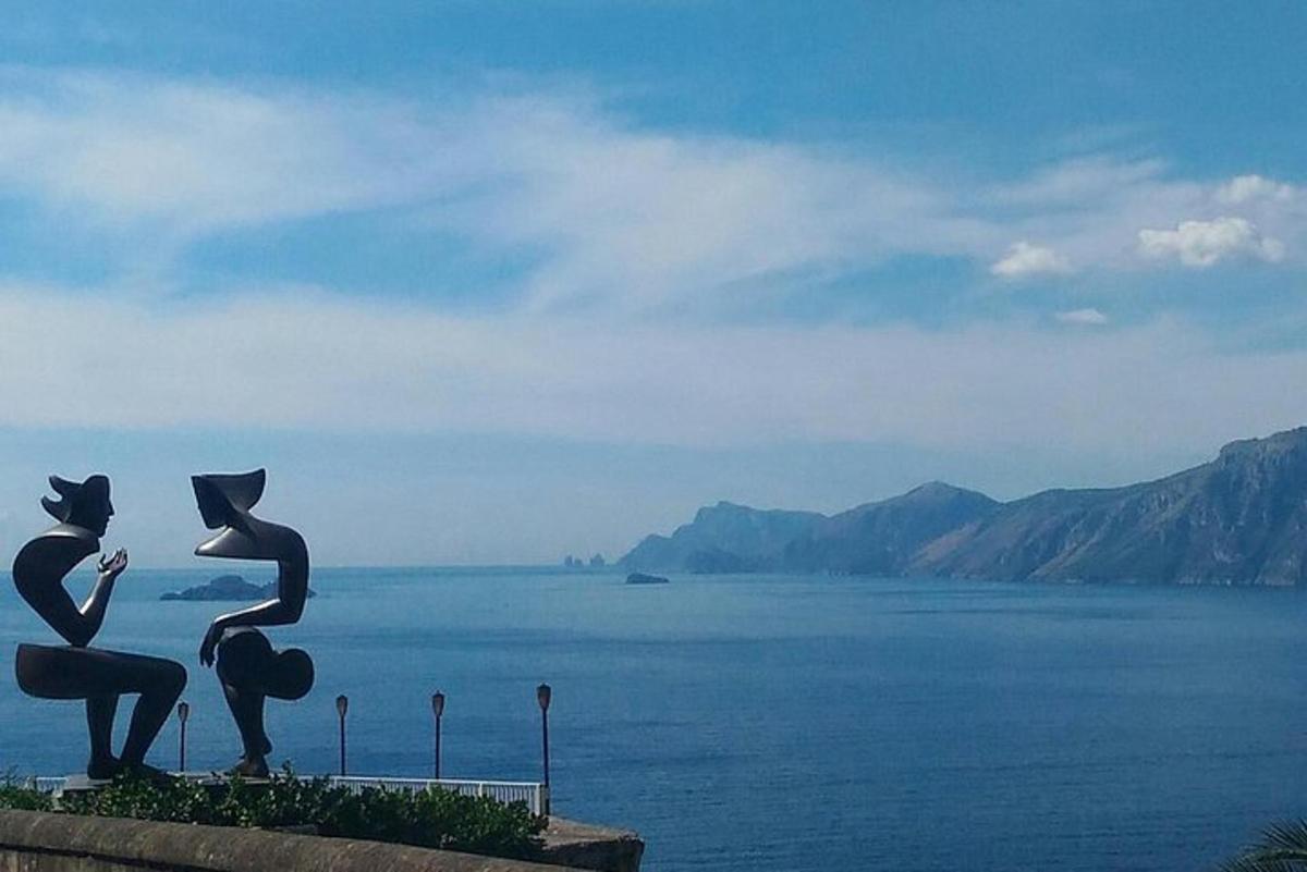a statue of two women looking at the water