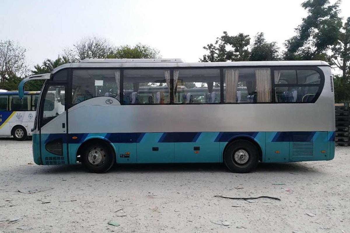 a blue and white bus parked in a parking lot