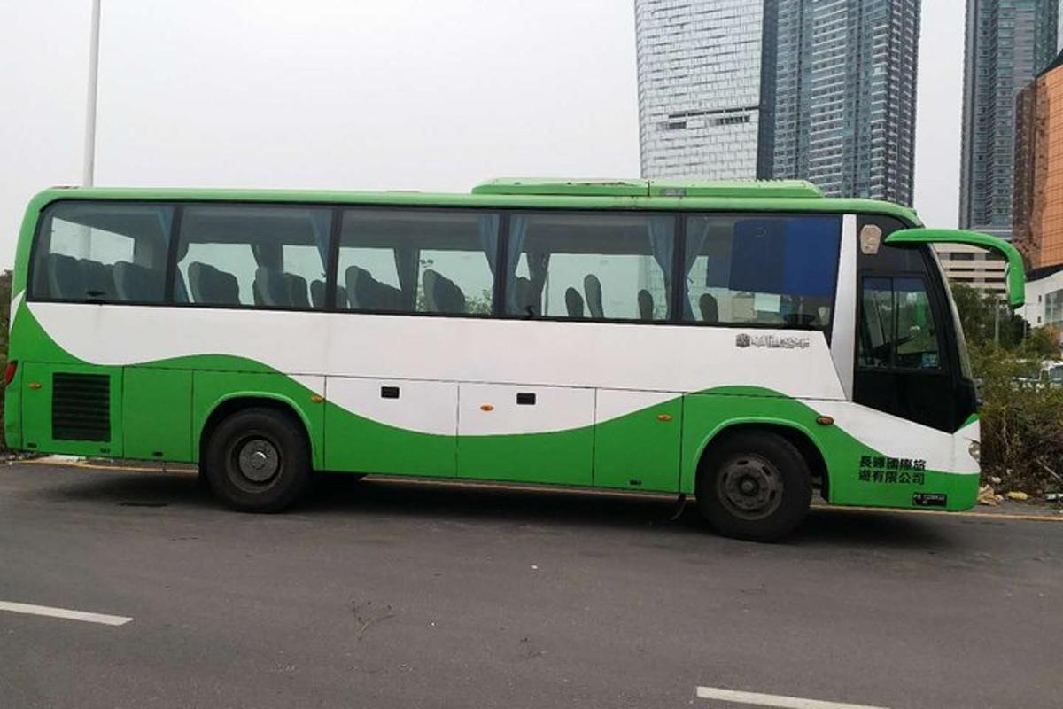 a green and white bus parked in a parking lot