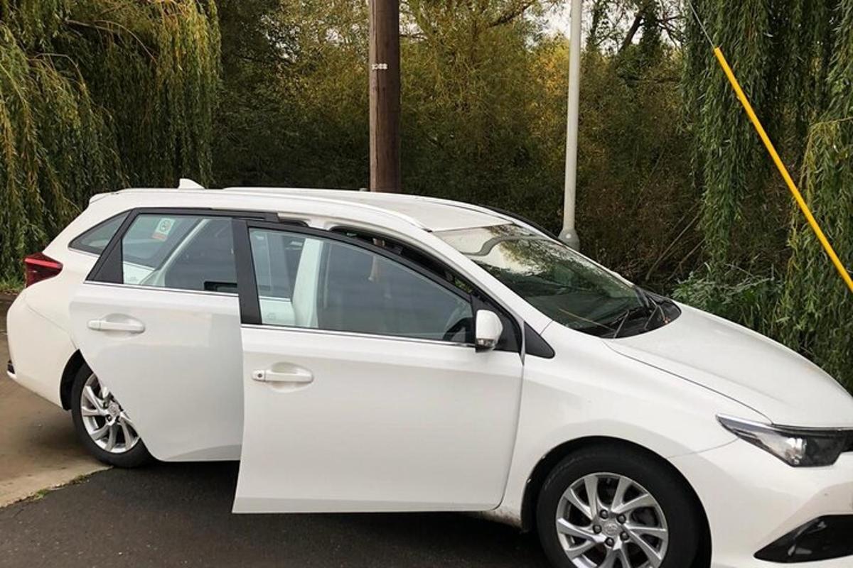a white car parked in a parking lot with its door open
