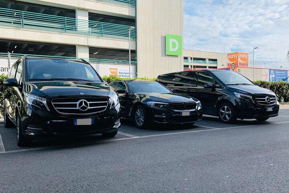 tiga buah kereta diletakkan di tempat letak kereta di hadapan sebuah bangunan