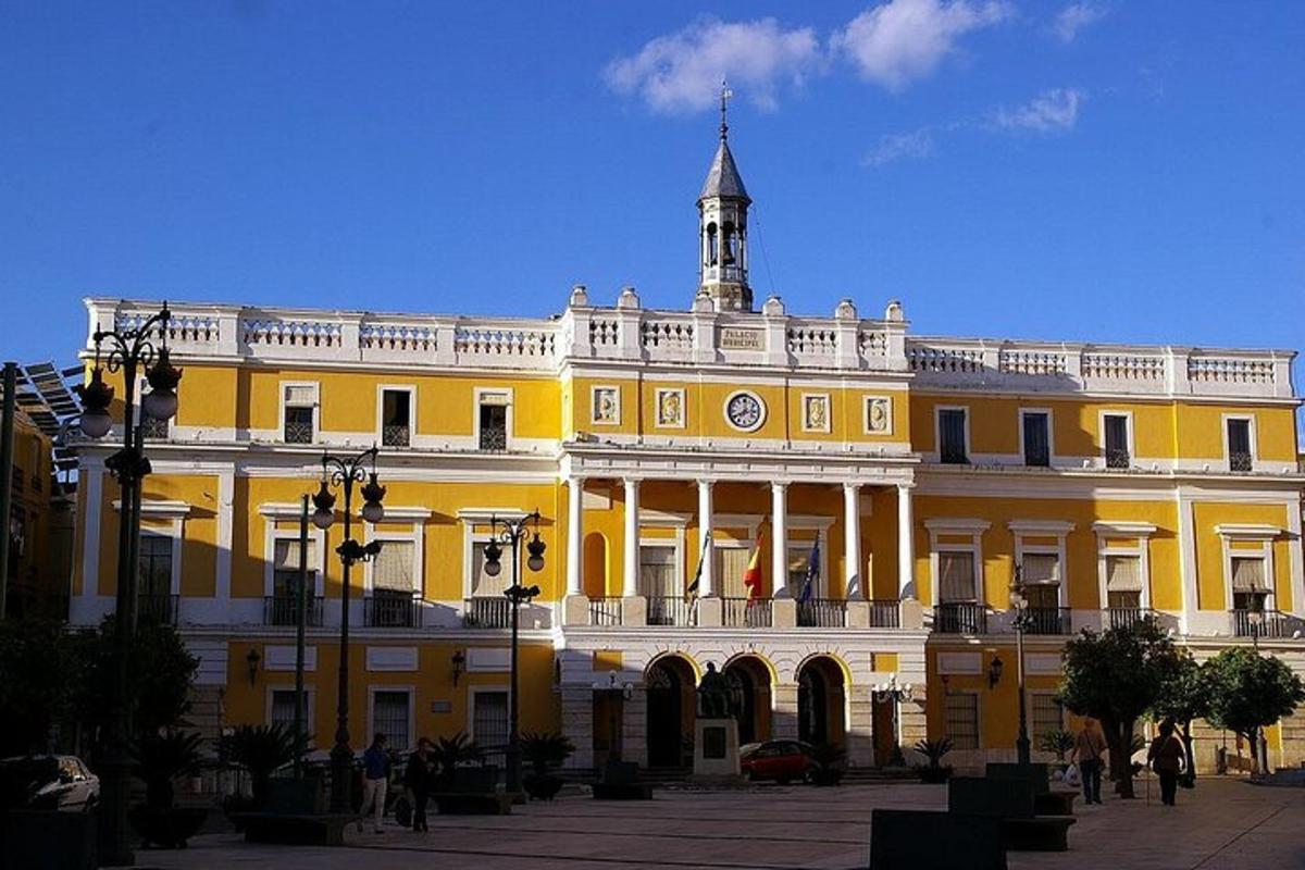 un grande edificio giallo con una torre dell'orologio in cima